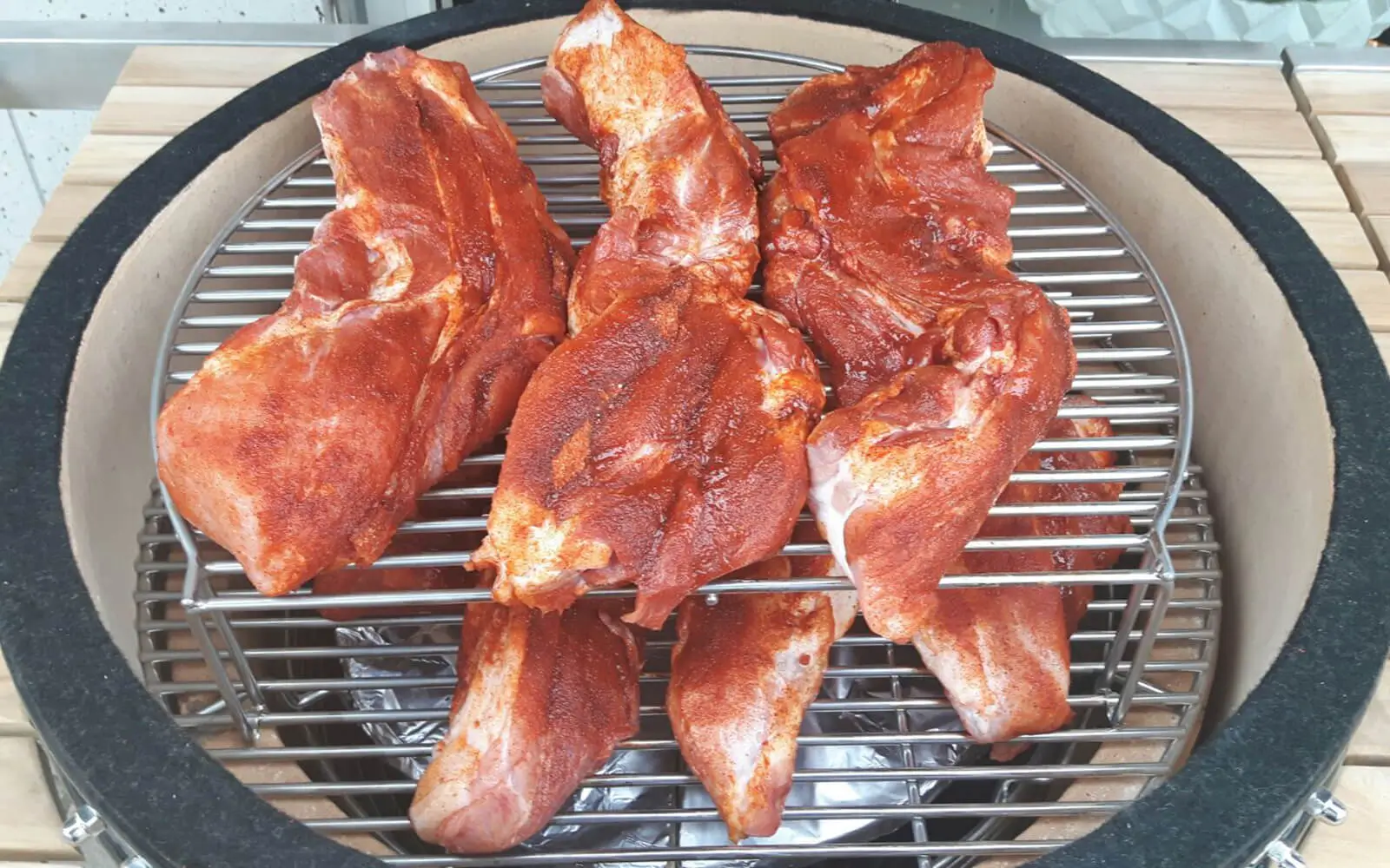 Stukken varkensvlees op de Monolith barbecue om pulled pork te maken