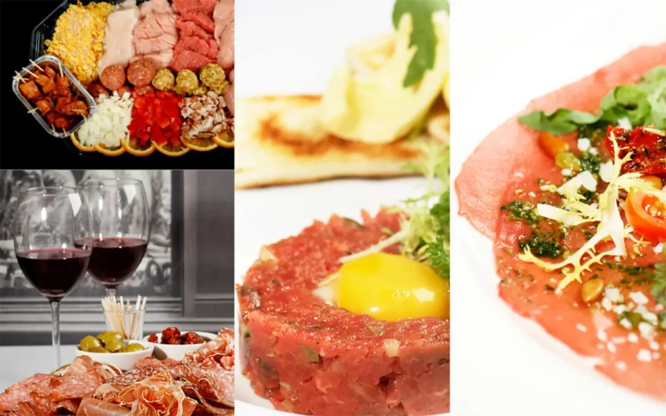 Compilatie van verschillende gerechten als gourmetschotel, glazen rode wijn, steak tartare, gerookte zalm